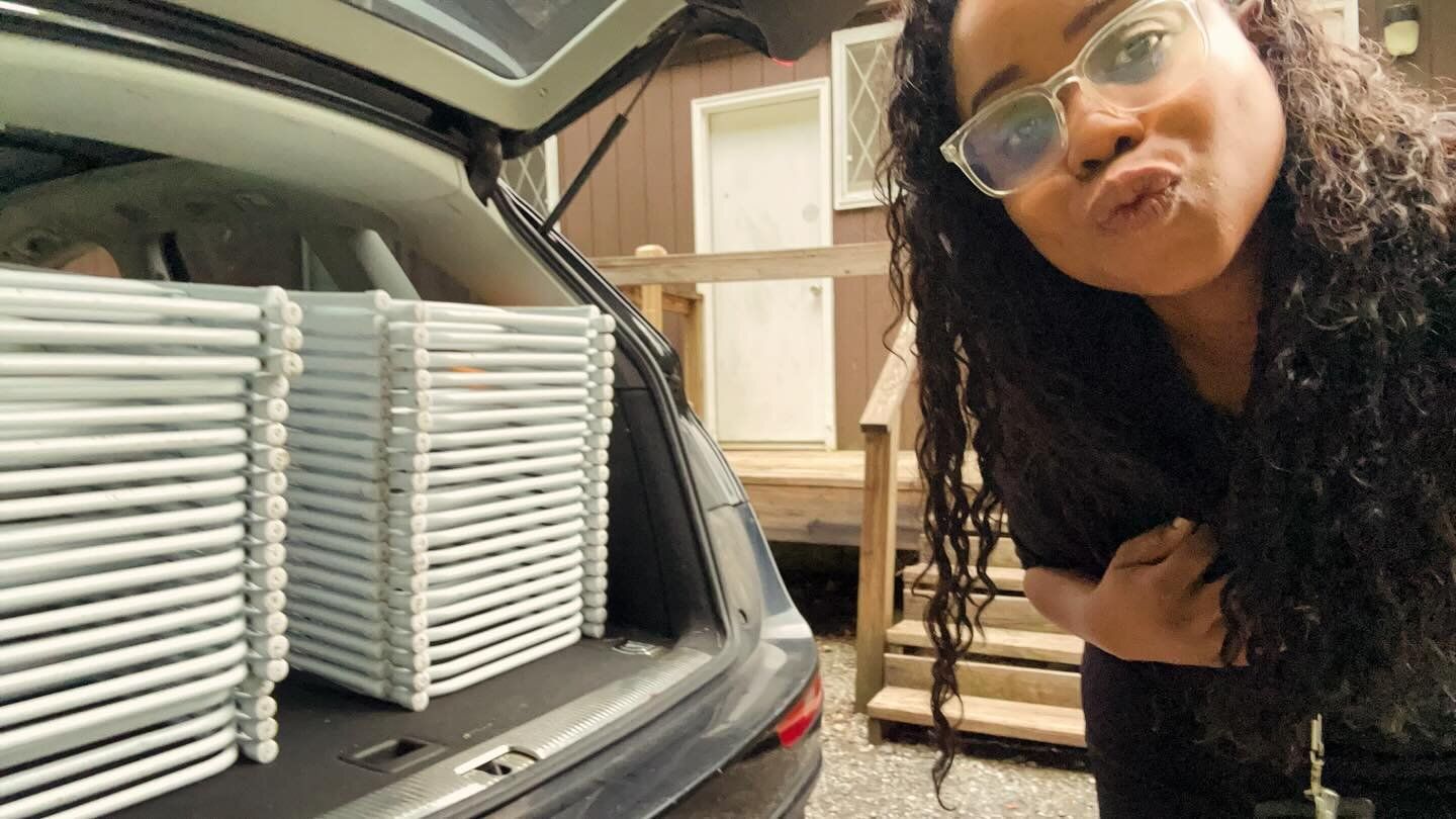 Patty beside her SUV with the trunk packed full of white folding chairs
